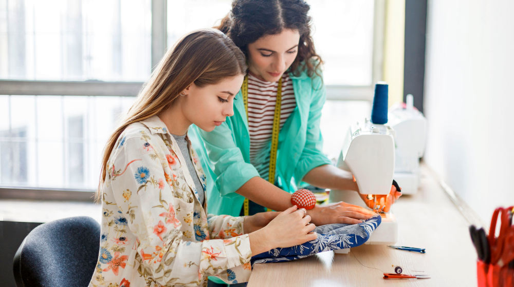 Pretty seamstress teaching girl working with sewing machine | Clever Sewing Projects To Upcycle Fabric Scraps | recycled fabric scraps | Featured